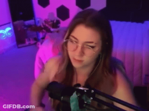 Woman With Glasses And Earrings Sitting At Microphone GIF