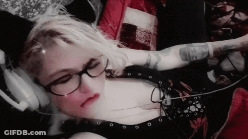 Woman With Glasses And Headphones Showing Arm Tattoo GIF