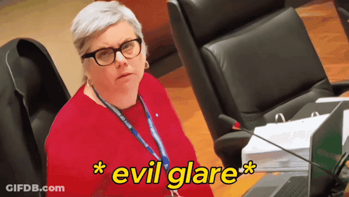 Woman With Glasses And Lanyard Evil Glare GIF