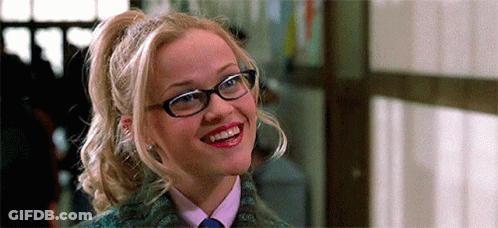 Woman With Glasses And Ponytail Smiling In Tie GIF