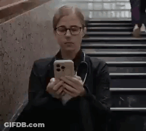 Woman With Glasses And Stethoscope Sitting On Stairs Looking At Phone GIF