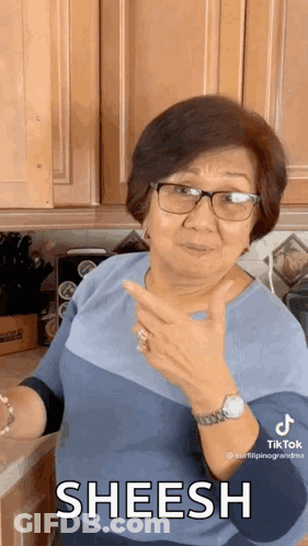 Woman With Glasses And Watch Giving Thumbs Up In Kitchen GIF