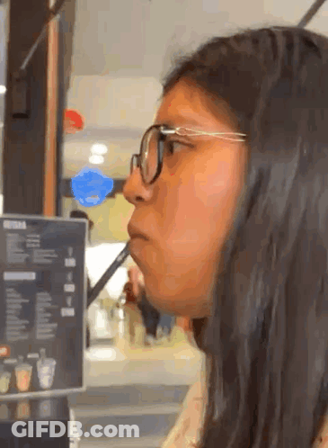Woman With Glasses Drinking From Straw At Menu GIF