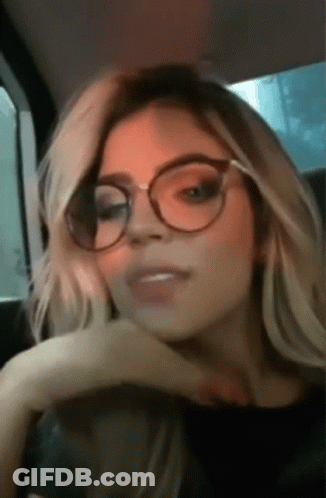 Woman With Glasses Hand On Chin In Car GIF