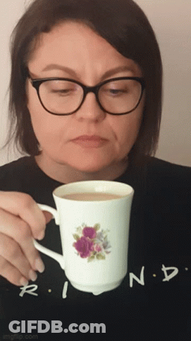 Woman With Glasses Holding Coffee Cup With Flower GIF
