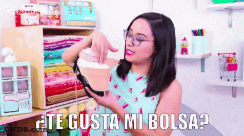 Woman With Glasses Holding Purse Saying Te Gusta Mi Bolsa GIF
