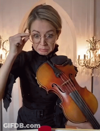 Woman With Glasses Holding Violin Making Face GIF