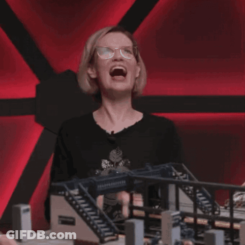 Woman With Glasses Laughing In Front Of Model Bridge GIF