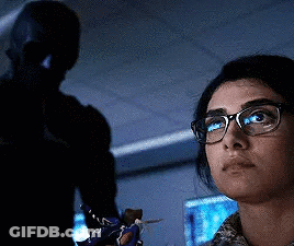 Woman With Glasses Looking In Dark Room With Man GIF