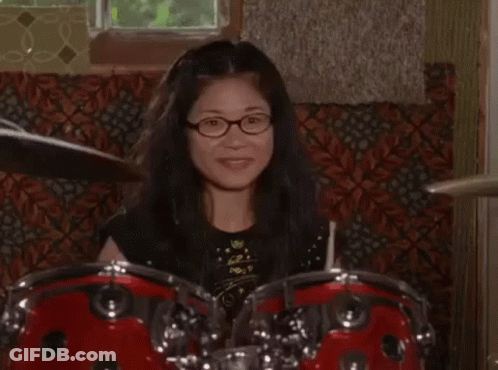 Woman With Glasses Playing Drum Set GIF