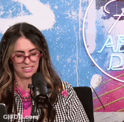 Woman With Glasses Sitting At Microphone In Studio GIF