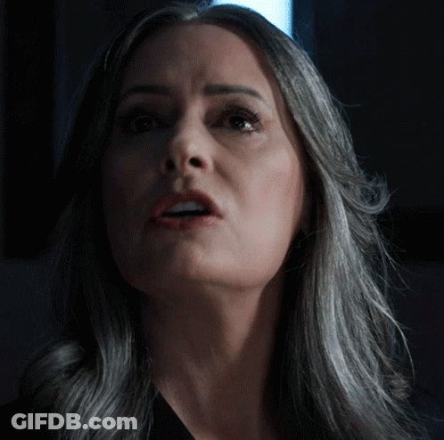 Woman With Gray Hair Looks Up At Camera GIF