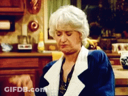 Woman With Gray Hair Making Funny Face In Kitchen GIF