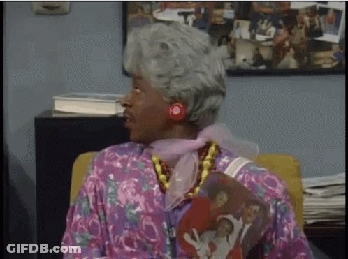 Woman With Gray Hair Sitting In Chair With Family Picture On Shirt GIF