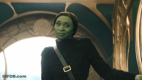 Woman With Green Face And Black Sweater And Shoulder Buckle GIF