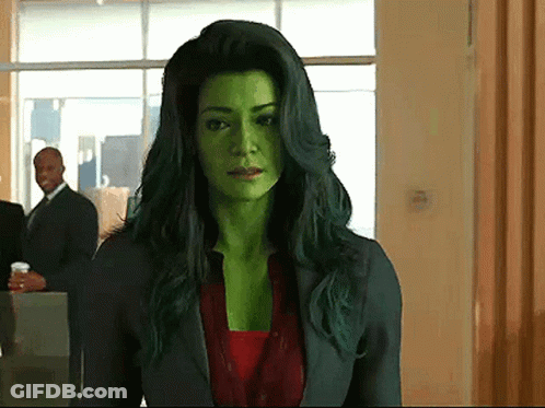 Woman With Green Hair And Green Face Standing In Hallway GIF