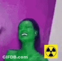 Woman With Green Hair Laughing In Front Of Purple Wall With Yellow Nuclear Symbol GIF