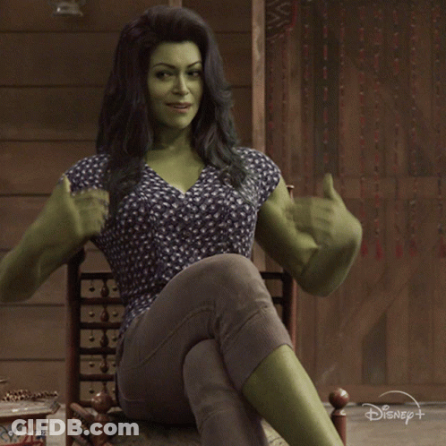 Woman With Green Muscles Sitting In Chair Saying Hello GIF