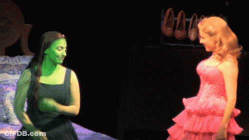 Woman With Green Paint Beside Woman In Pink Dress GIF