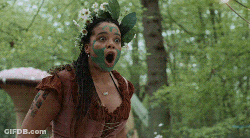 Woman With Green Paint On Face And Flower Crown GIF