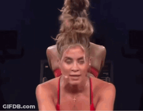 Woman With Hair Bun Riding Bike In Gym GIF