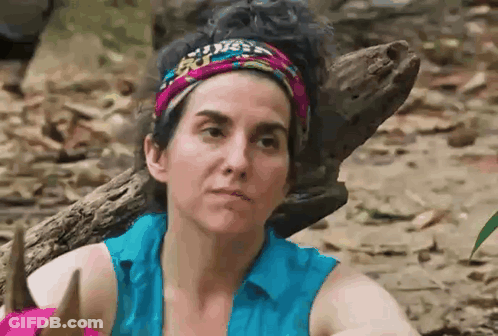 Woman With Headband And Blue Shirt Beside Log In Woods GIF