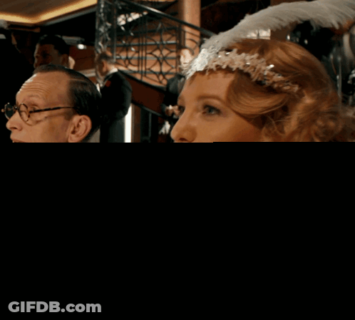 Woman With Headband Sitting Next To Man In Suit GIF