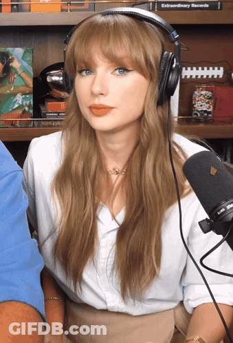 Woman With Headphones At Microphone In Front Of Bookshelf Saying Extraordinary Records GIF