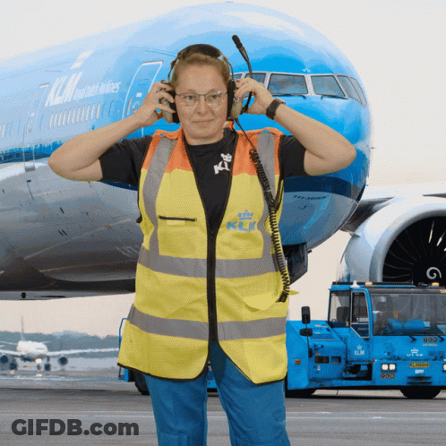 Woman With Headphones In Front Of Blue KLM Airplane GIF