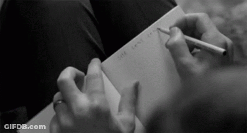 Woman With Headphones Writing At Desk GIF