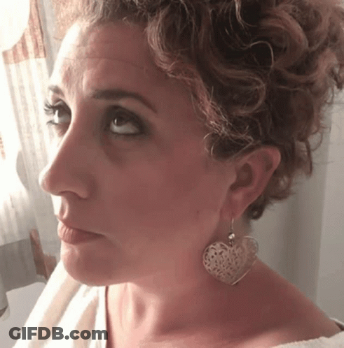 Woman With Heart-Shaped Earrings Looking At Camera GIF