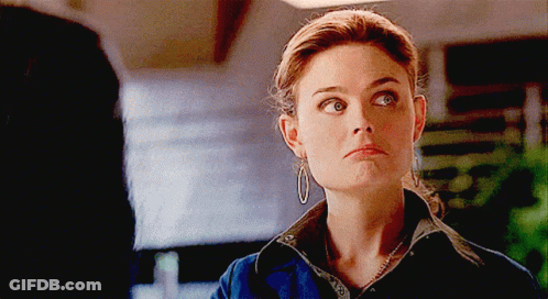 Woman With Hoop Earrings And Necklace Looking At Camera GIF