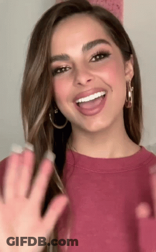 Woman With Hoop Earrings Smiling And Waving GIF