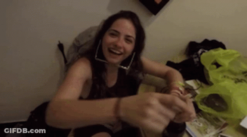 Woman With Hoop Earrings Smiling On Table GIF