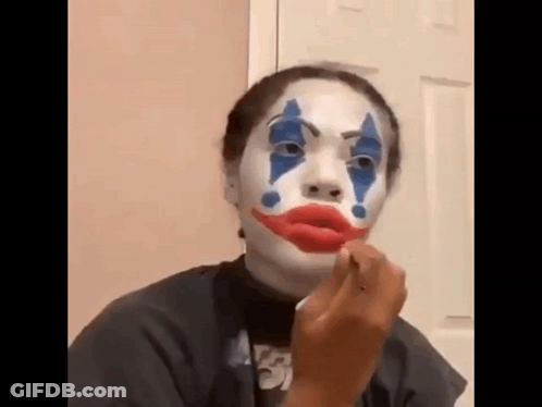 Woman With Joker Face Paint Applying Lipstick GIF