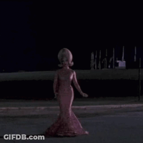Woman With Large Wig And Swirl Shirt GIF