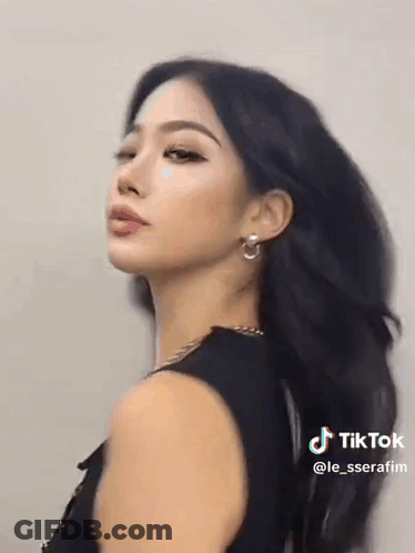 Woman With Long Black Hair And Earrings In Black Tank Top GIF