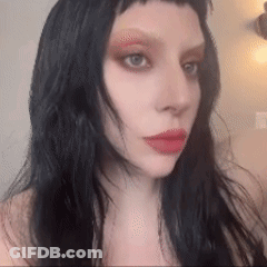 Woman With Long Black Hair And Red Lips Taking Selfie GIF