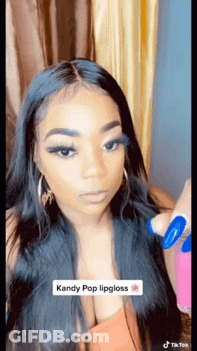 Woman With Long Black Hair Applying Kandy Pop Lipgloss GIF