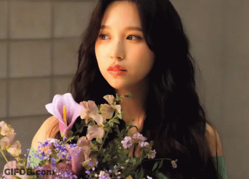 Woman With Long Black Hair Holding Flowers GIF