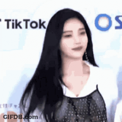 Woman With Long Black Hair In Front Of TikTok Wall GIF