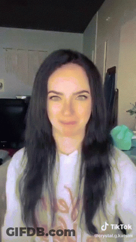 Woman With Long Black Hair In White Shirt Saying Love GIF