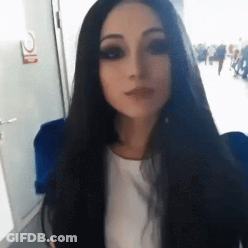 Woman With Long Black Hair In White Shirt Wearing Mask GIF