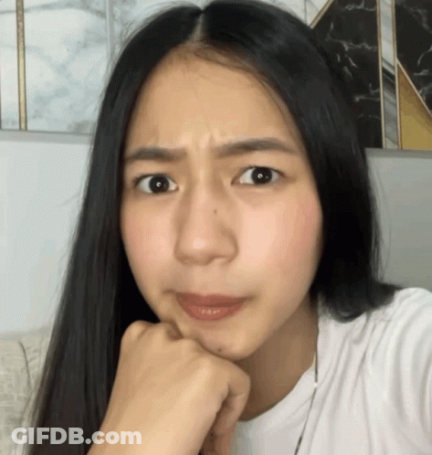 Woman With Long Black Hair Making Funny Face Hand On Chin GIF