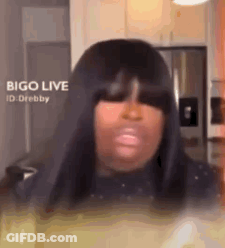 Woman With Long Black Hair Making Funny Face In Kitchen GIF