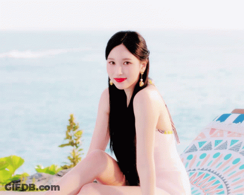 Woman With Long Black Hair Sitting Near Ocean GIF