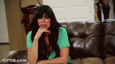 Woman With Long Black Hair Sitting On Leather Couch Hand On Chin GIF