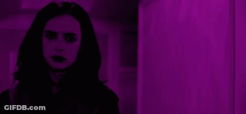 Woman With Long Black Hair Standing In Front Of Purple Wall GIF