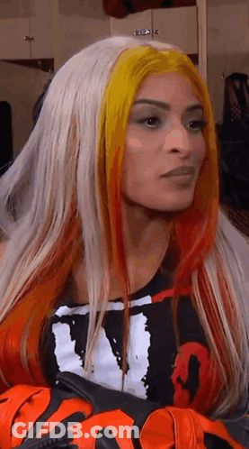 Woman With Long Blonde And Red Hair In Black And White Shirt And Gloves GIF