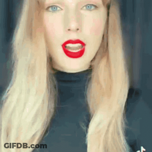 Woman With Long Blonde Hair And Red Lips In Black Turtleneck GIF